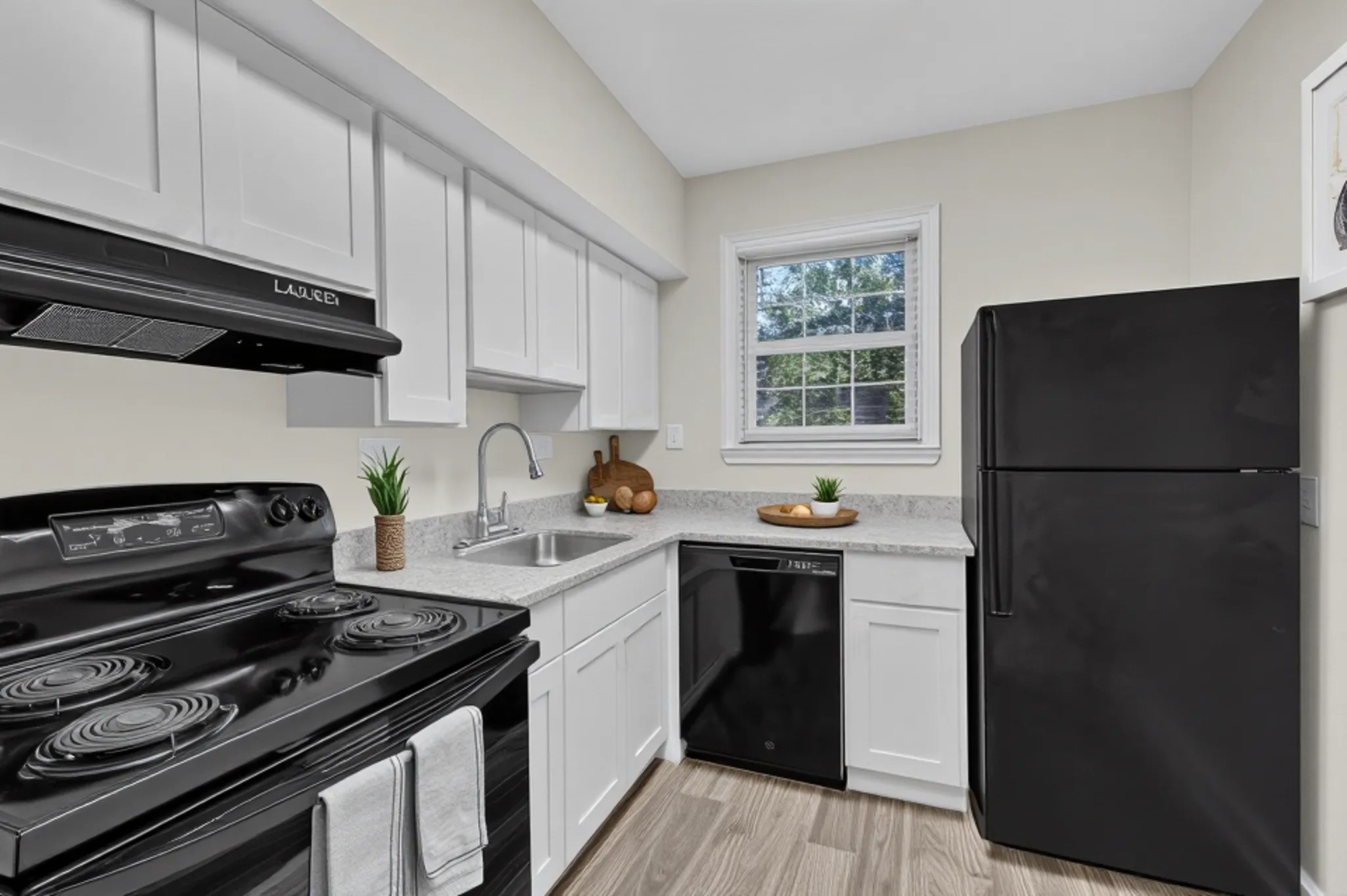Kitchen with white cabinets and black appliances